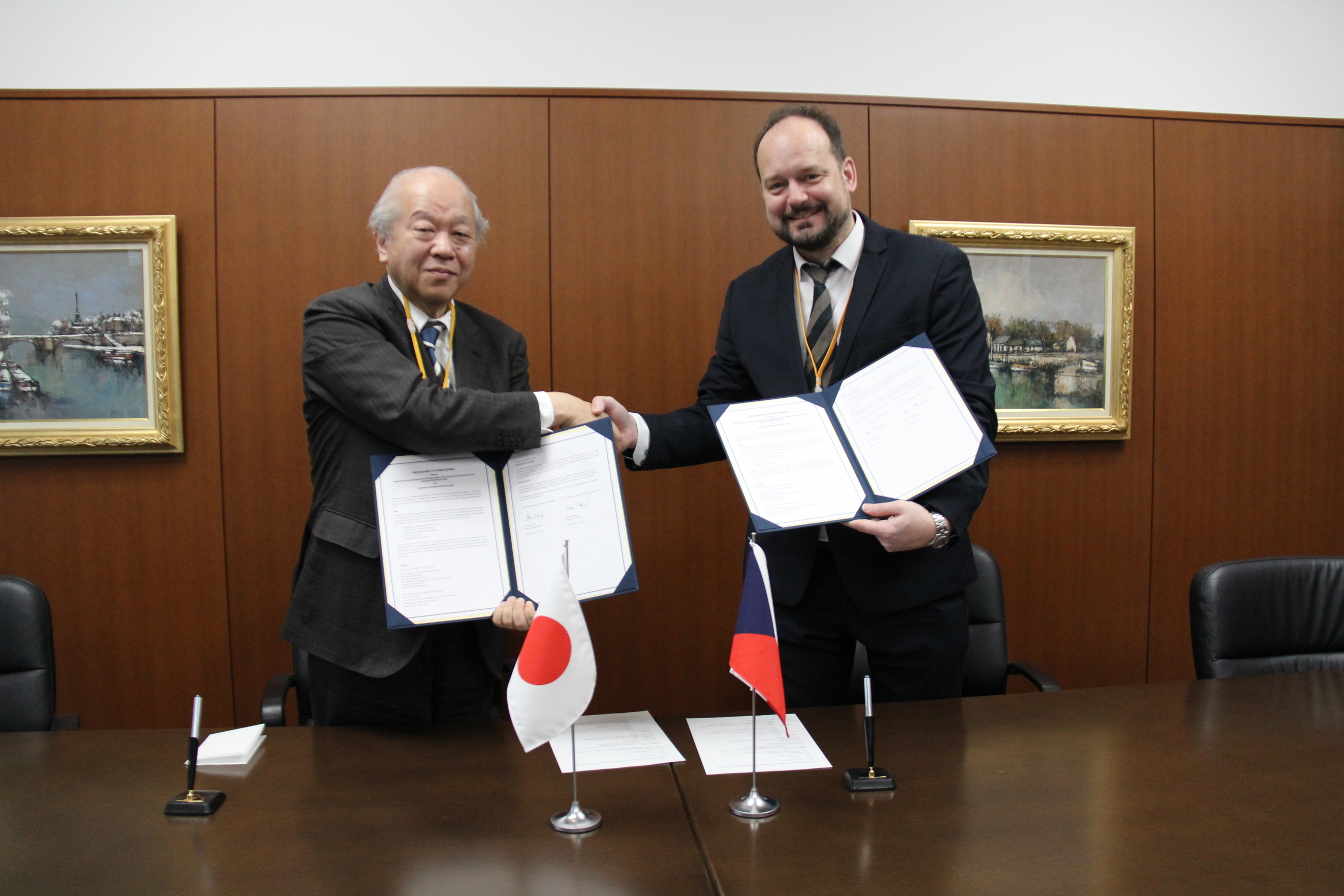 Prof. Tsubaki and Prof. Surovy shaking their hands with the MOU.